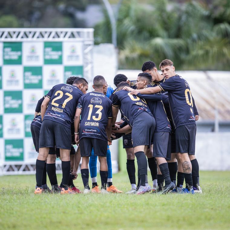 O grupo abraçado no meio do campo
